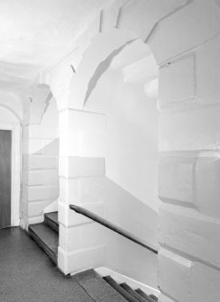 Interior. View of rusticated stairwell arches.