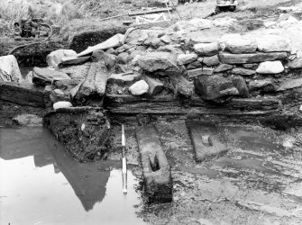 Excavation photographs: Trench XI. Stone causeway and timber raft, with timbers 2B and 3B; causeway; gatehouse forework with timber 4 after removal of later stone bridge abuttment; causeway; gatehouse; general view of causeway from gatehouse; E side of timber raft; water tank for timber preservation, with timber; general view of gatehouse forework; timber raft; water tank.