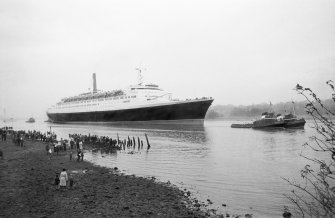 View looking SE showing QE II on River Clyde approaching Bowling with remains of pier in foreground