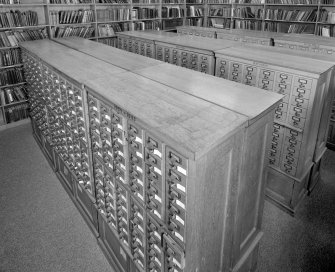 Interior.  Elevated view within library showing wooden cabinets containing drawers of index cards, cross-referencing Reports with reference books,journals and other records