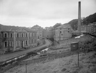 View of School, New Lanark, from South East with mill lade, side elevation of Institute and Retort House chimney.