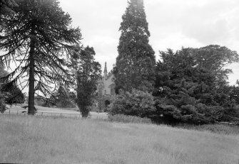 View of Cambusnethan Priory from NW partly obscured by trees.