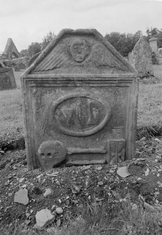 View of gravestone commemorating John Condie, 1720, with winged soul, pick and chisel, skull, double bones and hourglass, in the churchyard of Forgandenny Parish Church.