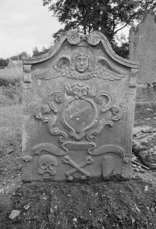 View of gravestone commemorating John Musfard, 1818, with winged soul, lion headed panel with sock and coulter of a plough, 'Memento Mori' ribbon, skull, crossed bones and coffin, in the churchyard of Forgandenny Parish Church.