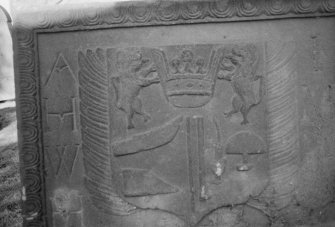 Detail of the tombstone commemorating Alexander Isles, 1744, with two lions supporting a crown, with the tools of a shoemaker, in the churchyard of Errol Parish Church.