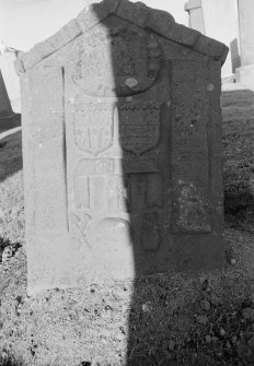 General view of gravestone commemorating Andrew Adam and dated 1746 in the churchyard of Errol Parish Church, with two shields containing the emblems of a ploughman and those of a weaver, with 'Memento Mori' ribbon, hourglass, sexton's tools, skull and coffin below.