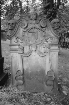 View of gravestone commemorating Samuel Gilmore 1805 in St Cuthbert's Churchyard, Edinburgh, showing soul top centre in silhouette, cartouche with square and compasses, and second soul centre drape.