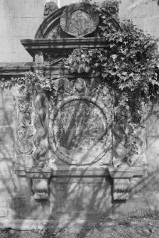 View of mural monument commemorating John Burnett, 1722, in the churchyard of Bo'ness Parish Church, showing ivy, shell-like monogram at top and soul between twisted pilasters.