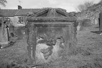 View of headstone commemorating I.R. and I.M. in the churchyard of Bo'ness Parish Church, showing  a flying angel with trumpet and riband, coopers tools incised.