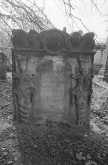 View of headstone commemorating William Cumming, 1778, in the churchyard of Bo'ness Parish Church, showing two caryatids with twisted columns, and above, twin souls with circlet.