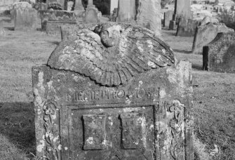 View of gravestone commemorating Daniel Thomson, 1721, in the churchyard of St Serf's Parish Church, Alva. with soul at the top of stone, 'Memento Mori' inscribed below and two carvings of the mason's castles in the panel.