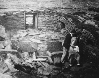 Excavation photograph, 1929-30. Copy negative 1995. Original print in Print Room.
Original photograph annotated on back:"Still from Society of Antiquaries Scotland's first Archaeological film showing buildings excavated at Papa Westray Orkney by William Traill   C E. F. S. A. Scot. and William Kirkness F. S. A. Scot.
                       copyright-
                                William Kirkness
                                  6 Learmonth Place
                                    Edinburgh."