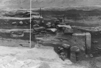 Excavation photographs: film card; view of midden from W showing erosion face; masonry in central section; pre-ex of human grave and associated feature; burnt material F180; F180 section; central masonry; revetting wall stones; post-ex of pit F290 cutting grave; post-ex of grave F292 with skeleton F220; view of masonry in section from W; F106 in section.