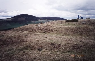 Defences at the SW end of the fort. Mr A Leith and MrJR Sherriff (both RCAHMS) in picture; Tap o' Noth hillfort (NJ42NE 1) in background

