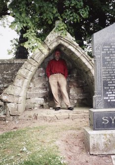 View of medieval grave-monument; Mr P Corser (RCAHMS) in picture