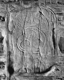 General view of Pictish stone bearing an unusually curved variant of the horse-shoe symbol above a disc enclosing three smaller circles.