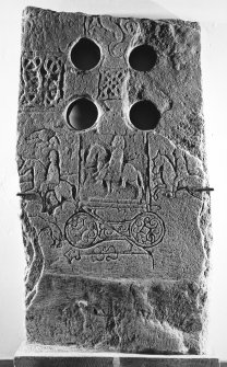 General view of Pictish cross-slab bearing a hunting scene, double-disc, Z-rod and, to the left of the upper arm of the cross, two lines of inscription.