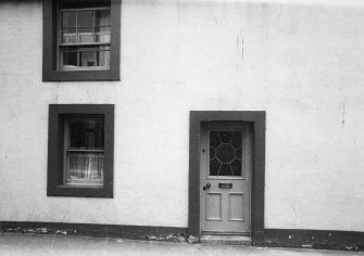 View of front door and ground floor and first floor windows.