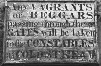 Detail of warning notice to vagrants and beggars adjacent to NE range's central block archway on NE side.