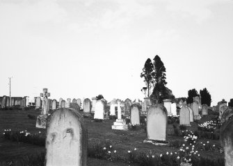 General view of graveyard and distant view of church.
