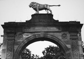 Detail of upper archway showing date and carved stone lion.