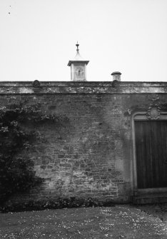 View of wall and gate with clock tower behind.