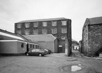 View from SE across yard, showing four-storeyed mill building.