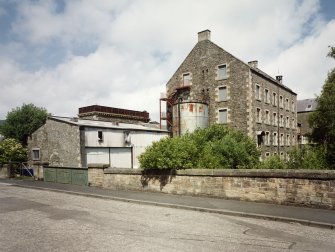 General view of multi-storeyed mill (building No 1, former twisting and reeling mill) and boiler and engine houses from S (buildings Nos 3 and 3A).