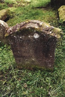 Minto House, Church and Graveyard.
18th Century gravestone in burial enclosure. View of stone inscription which reads: 
Here lies
John Henderson 
late ____ at Paper
law who died on
the 9 of October
1724 his age 66
D4452 show the opposite face of the headstone. Showing an angel over hourglass, skull and cross bones with ornamental surround.


