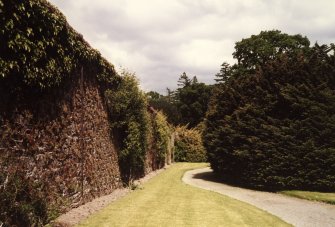 View of serpentine path bordering walled garden.
