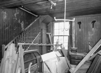 Interior. Harness room, view showing saddle hooks and stair to room above