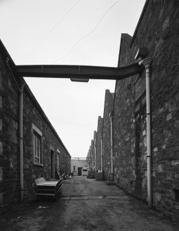 Peebles, March Street, March Street Mills
View from north east in passage between north block of works (left) and central block (right), the latter containing the former engine and boiler houses.  A cast-iron beam spans the gap between the two blocks