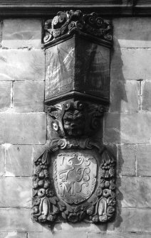Detail of sundial and carved shield above front door.