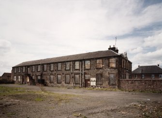 General view of surviving two-storeyed mill block from NE.