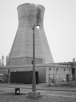 View of factory street lamp and concrete cooling tower.