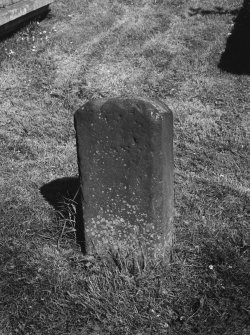 View of chamfered edge on rear face of reused medieval gravestone set on end.