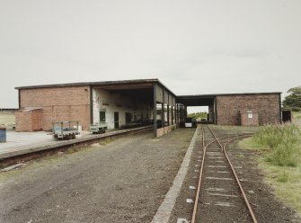 View from SW of railway dispatch buildings [V1, V2 and V9], latterly converted for road transport. View also shows examples of bogeys used on narrow gauge railway throughout plant