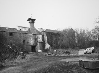 View from SE of rear of central part of main block of farm buildings, including former kiln.