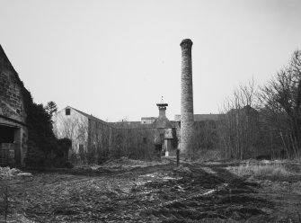 General view of farm buildings and chimney stack (former distillery) from ESE.