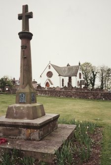 General view from E with cross shaped war monument in foreground.