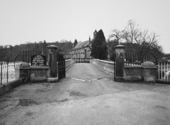 View from NNE of gates at N end of bridge with parish church in background.
