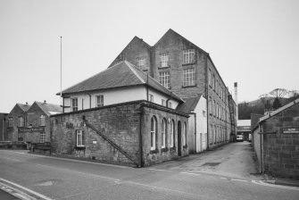 General view from N of the NE end of the works, showing the N gable of the High Mill, and the offices and gatehouse in the foreground.