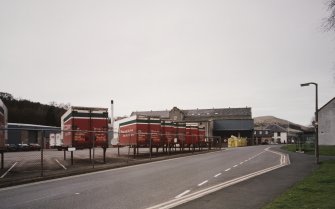 Distant view of the mill from SE, with Edinburgh Woollen Mills trailers in the foreground.