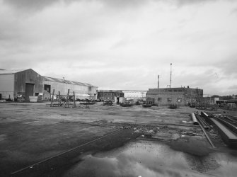 General view from SW of office/canteen building (L) and Compressor House (R), with Chapelcross Nuclear Power Station on horizon in distance