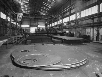 Plate Fabrication & Cylinder Fabrication (Bay 1): view showing end plates of boilers in foreground, and profile cutter to cut plate steel to desired shapes and sizes