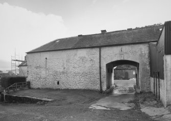 View from NW of arched entrance into yard of steading