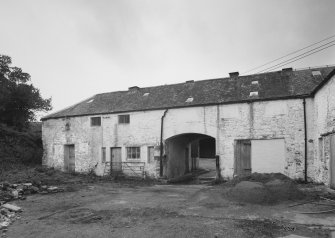 View from SE within yard showing arched entrance through NW wing of steading