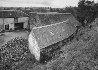 Elevated view from SW showing the three bays of the cattle shed (with curved bay in foreground), also showing the NE wing of the steading and the farm house in the background