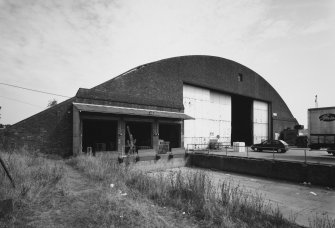 Oblique view from WSW of SSW end of hangar, showing added loading bay doors (left) and main (sliding) doors