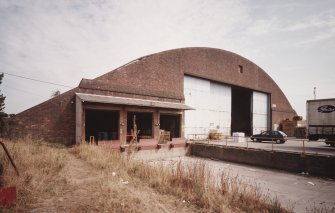 Oblique view from WSW of SSW end of hangar, showing added loading bay doors (left) and main (sliding) doors